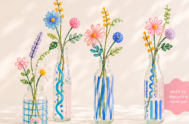 Colourful beaded botanicals in painted glass vessels